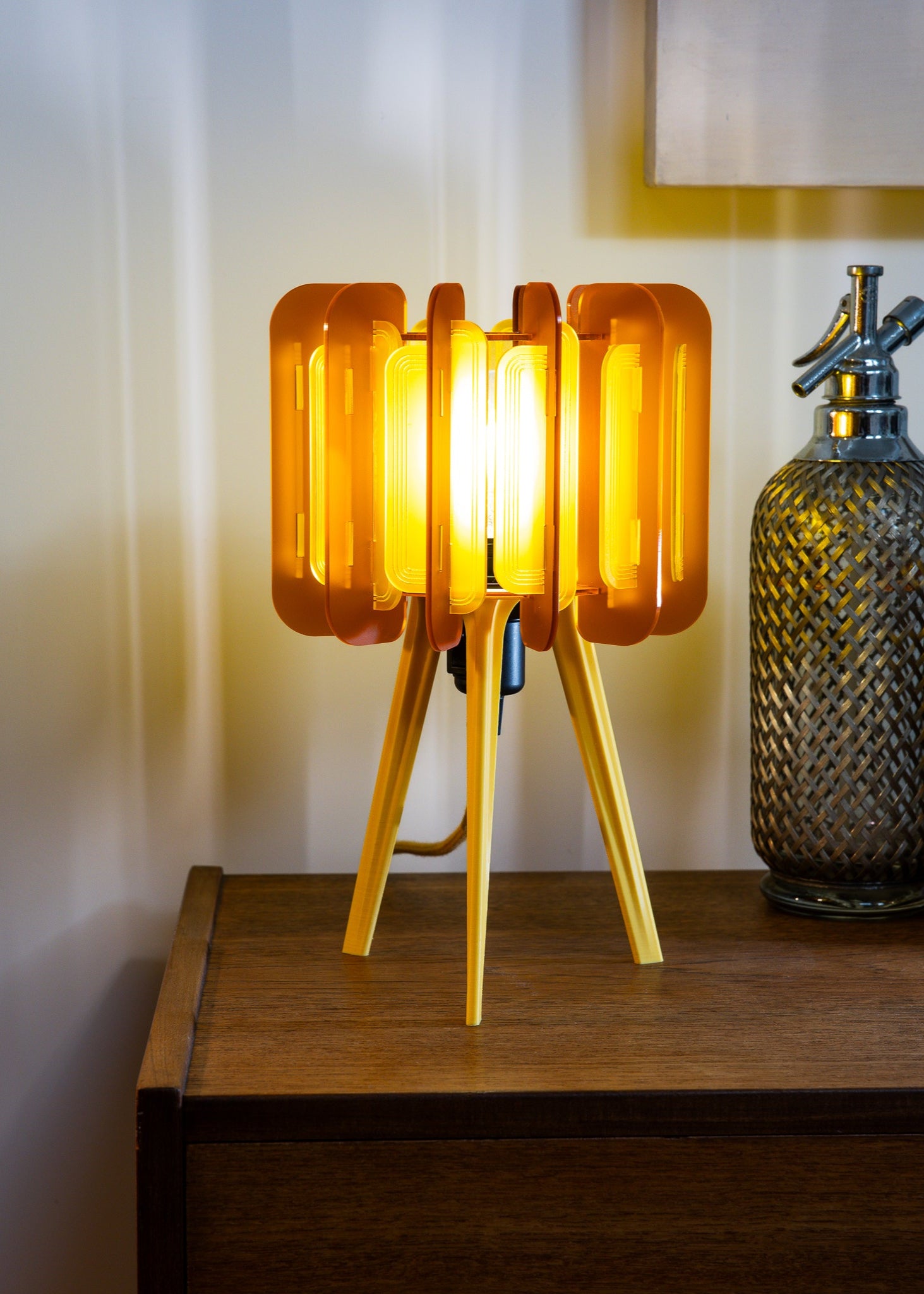 Burnt Orange Mini Poppy lamp shown on a floating shelf, paired with ceramics and books. Its warm tone and laser-cut texture bring a bold accent to earthy, vintage, and eclectic interiors. A handmade lamp for lovers of maximalist home decor.
